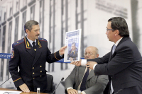 Редактор отдела Общество вручает подарочную первую полосу Парламентской газеты, приуроченную к 77-летию ГАИ