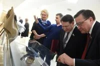 Художник Владимир Нуждин (второй слева) рассказывает сенаторам о технике своей работы