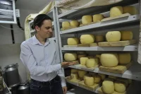 Исполнительный директор центра «Вдохновение» Владимир Купавский демонстрирует стенд с козьими сырами
