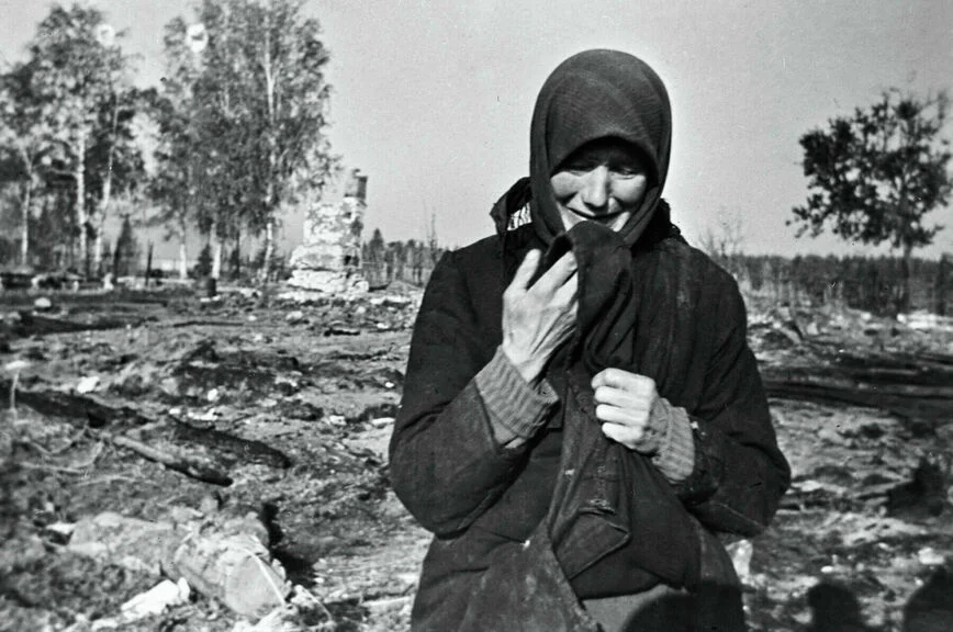 Женщина плачет на развалинах родного села, сожженного фашистами во время Великой Отечественной войны.